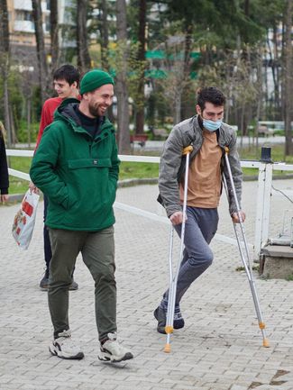 Владимир (на костылях), его брат (в красном) и волонтер в Тбилиси