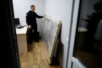 Алексей Небитов рядом с фрагментом фасада, на котором изображен рисунок Бэнкси 