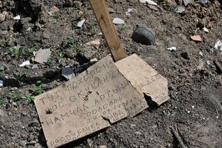 Дощечка с надписью «Тут похоронен рос. оккупант» на могиле, выкопанной местными жителями в селе Малая Рогань под Харьковом
