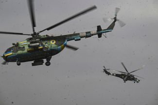 Вертолеты Ми-8 (слева) и Ми-24 (справа) вылетают на задание