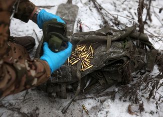 Санитар ВСУ высыпает патроны из подсумка бойца, раненного в боях под Соледаром
