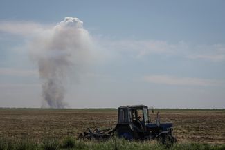 Водитель трактора на сельхозработах во время обстрела на правом берегу Днепра, находящемся под контролем Украины. 