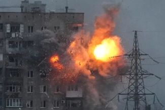 An explosion in a large apartment building after a Russian tank fired on it.