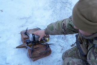 Оснащенный боеприпасом FPV-дрон готовится к запуску военнослужащими роты «Рарог» на позициях близ Горловки