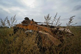 Подбитый российский бронетранспортер в поле недалеко от недавно освобожденного поселка Высокополье
