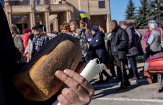 Люди стоят в очереди за хлебом, свечами и едой в Балаклее, освобожденной от российской оккупации. Харьковская область, 21 сентября 2022 года