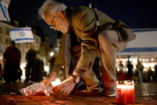 Люди зажигают свечи на акции солидарности с Израилем. Франкфурт, 7 октября 2023 года