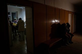 Женщины ждут в коридоре госпиталя возле операционной, где врачи пытаются спасти их раненого родственника