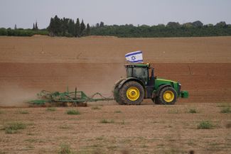 Фермер работает в поле недалеко от границы Израиля с сектором Газа. 25 ноября 2023 года