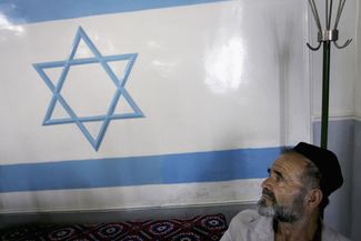 Daniel Davidov, an Uzbek Jew, looks up at an Israeli flag in the only remaining synagogue in Fergana, Uzbekistan. August 14, 2006.