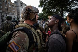 Протестующий смотрит на бойца Национальной гвардии. Вашингтон, 3 июня 2020 года
