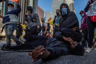 Протестующие в Лос-Анджелесе разыгрывают сцену задержания Джорджа Флойда, 30 мая 2020 года