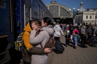 A mother at a railway station in Lviv hugs her son, who escaped from Mariupol.