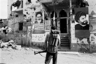 Боевик «Хизбаллы» перед портретами аятоллы Хомейни и основателя группировки, Мухаммада Хусейна Фадлаллы. Бейрут, Ливан, 1984 год