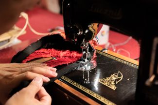 Nguyen sewing a costume in his studio. 2019.