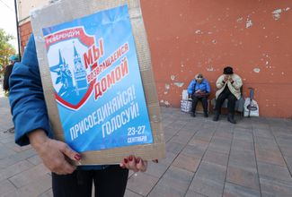Женщина с плакатом «референдума» о вхождении самопровозглашенной ДНР в состав России в Мариуполе