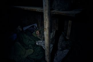 Украинский солдат спит в землянке на передовой в Бахмуте