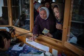 Женщины получают гуманитарную помощь в церкви в Буче. В городе, который стал одним из самых страшных символов этой войны, по-прежнему нет воды, газа и электричества
