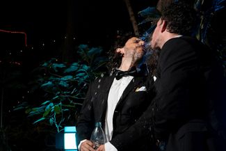 Участники исполнительского коллектива «Люди-фонтаны» плюют друг другу в рот на вечеринке в честь снятия коронавирусных ограничений в Калифорнии. Лос-Анджелес, 15 июня 2021 года