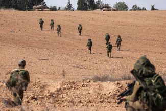 Израильские солдаты занимают позиции в районе кибуца Кфар-Аза, который расположен примерно в пяти километрах от сектора Газа