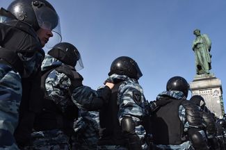 Отряд полиции выстраивается в линии, чтобы блокировать протестующих на Пушкинской площади