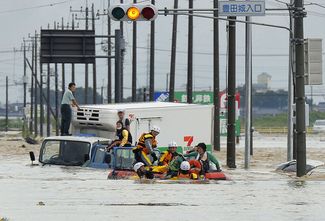 Пожарные помогают пострадавшим в затопленном фургоне, 10 сентября 2015 года