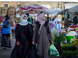 Women shop for food at Mehrgon Bazaar in Dushanbe. April 2024.