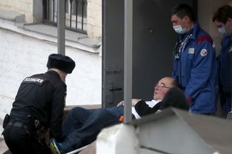 Сотрудники скорой помощи вынесли Бориса Шпигеля на носилках из здания Басманного суда. Москва, 22 марта 2021 года