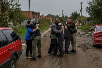 Жители села Каменка Харьковской области обнимают друг друга после возвращения из эвакуации. Каменка перешла под контроль ВСУ в сентябре