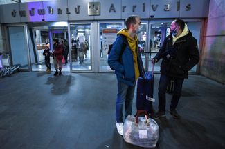 Россияне и белорусы с вещами ждут такси у дверей аэропорта в Ереване. 10 марта 2022 года
