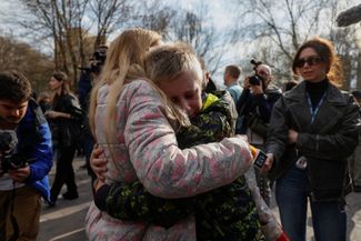 Ирина обнимает своего 13-летнего сына Богдана, вернувшегося из «летнего лагеря» в России, куда он был вывезен с оккупированной территории Украины