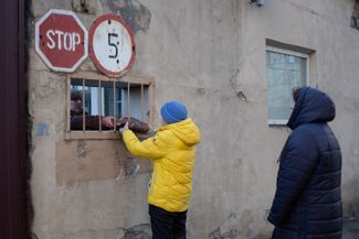 Люди получают бесплатный хлеб на хлебной фабрике в Киеве. 28 февраля 2022 года