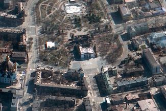 A satellite image shows the aftermath of an airstrike on a drama theater in Mariupol, where civilians were sheltering in the basement. The word “children” is written on the ground outside of the theater in Russian script. 