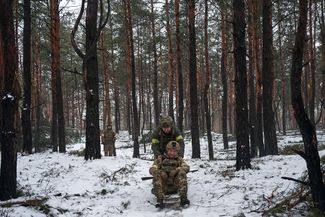 Украинские военные катаются на санках, которые они нашли в лесу. Разведбатальон ищет места, подходящие для строительства новых укреплений