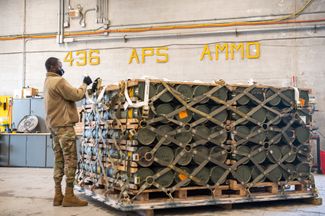 Американские военнослужащие укладывают на поддоны боеприпасы, оружие и другое оборудование, которое отправят в Украину в рамках миссии по продаже иностранной военной продукции. База ВВС США Дувр, штат Делавэр, 21 января 2022 года