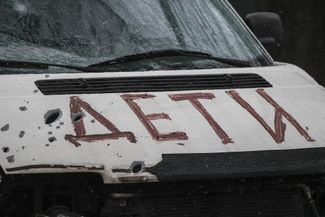 Машина из Бучи с надписью «ДЕТИ» и осколочными отверстиями на капоте
