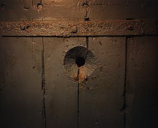 A peephole leading into an isolation cell.