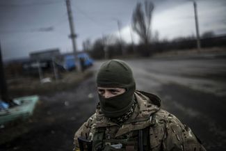 A Ukrainian soldier stands watch on a road between Debaltseve and the Ukrainian-controlled town of Artemovsk.