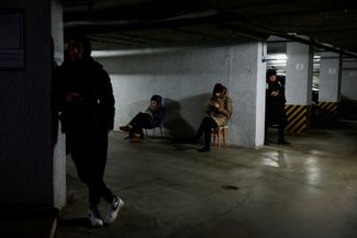 Люди укрываются на подземной парковке во время ракетной тревоги в Киеве