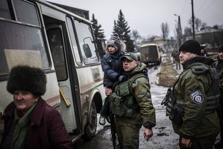 A Ukrainian army soldier holds a Ukrainian kid while evacuating citizens from Debaltseve, February 3, 2015.