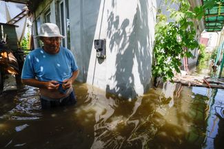 53-летний житель Новой Каховки Валерий в своем доме, затопленном водой, 7 июня 2023 года