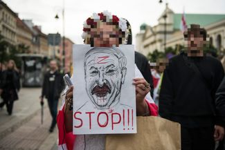 A woman holds a caricature of Aleksander Lukashenko during a march in Warsaw protesting political repressions in Belarus. August 9, 2023.