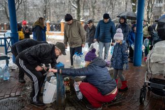 Люди набирают воду в Киеве 24 ноября. После серии российских обстрелов половина города остается без электричества. По словам мэра города Виталия Кличко, власти делают все, чтобы вернуть свет «как можно быстрее», однако точные сроки будут зависеть от восстановления баланса в энергосистеме Украины