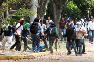 Члены провластной группировки колективо разгоняют студенческий оппозиционный митинг. Каракас, апрель 2014 года