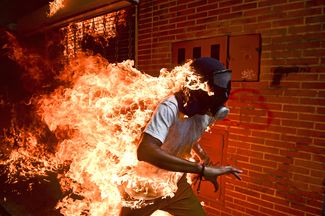 Фотография года: Хосе Виктор Салазар Бальза — участник акции протеста против президента Венесуэлы Николаса Мадуро в Каракасе 3 мая 2017 года — в огне