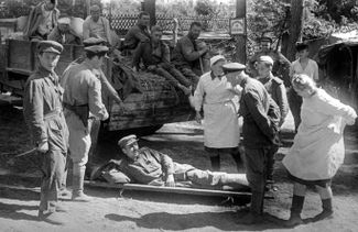 Начальник полевого госпиталя, гвардии майор Просов осматривает раненого. Ростовская область, 1942 год