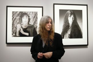 Патти Смит на выставке фотографий Роберта Мэпплторпа в Париже (на фоне своих портретов, сделанных фотографом), март 2014 года