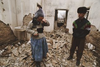 Ingush people stand in their destroyed home. 1992.