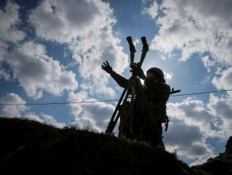 Украинский военнослужащий с биноклем на линии фронта, Киевская область