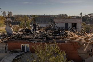 Житель Херсона на крыше своего частного дома, практически полностью разрушенной в ходе обстрела города ВС РФ. 30 октября 2023 года